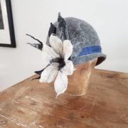 Handgefertigter Filz-Hut mit dekorativen Stoffblumen, Federn und blauer Schleife, ideal für kreative Mode-Accessoires und handgemachte Unikate.
