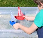 Selbstgemachte Spielzeug-Boote und ein Plakat dazu