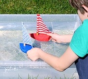 Selbstgemachte Spielzeug-Boote und ein Plakat dazu