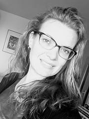 Porträt einer Frau mit Brille, lächelnd, in Schwarz-Weiß, authentisch und kreativ, passend für Handmade- und Kulturthemen.