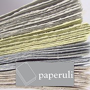 Stapel handgefertigter Papierbögen in verschiedenen Farben und Texturen, ideal für kreative Bastelarbeiten und nachhaltige Kunstprojekte.