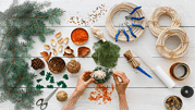 Kreatives Basteln mit Naturmaterialien für festliche Weihnachtsdekoration, inklusive Zweige, Tannenzapfen, Schleifen und Bastelwerkzeuge, für nachhaltige Handwerkskunst.