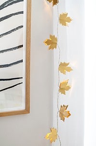 Goldene Lichterkette mit Herbstblättern