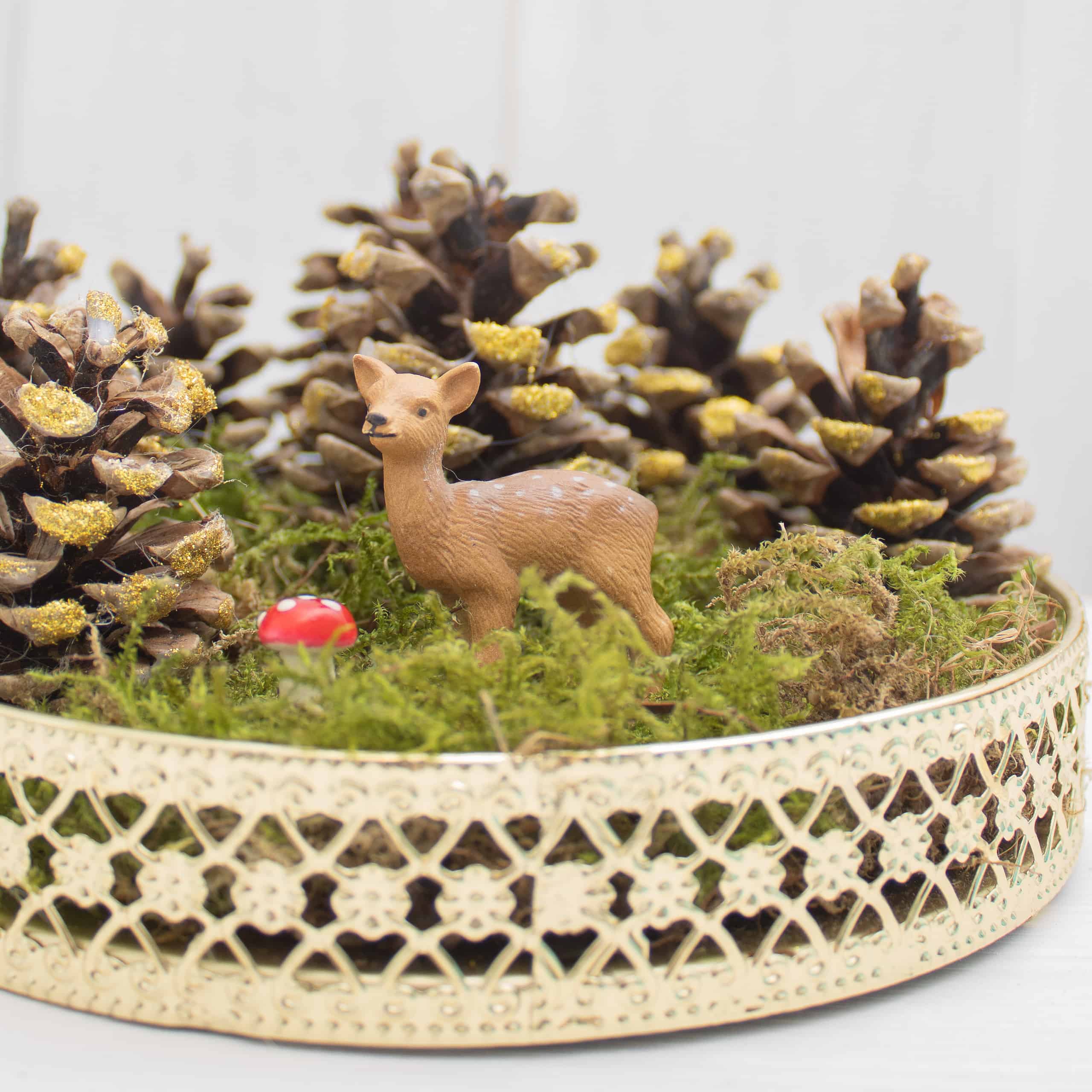 Herbstliches Stillleben mit Zapfen und Tierfigur