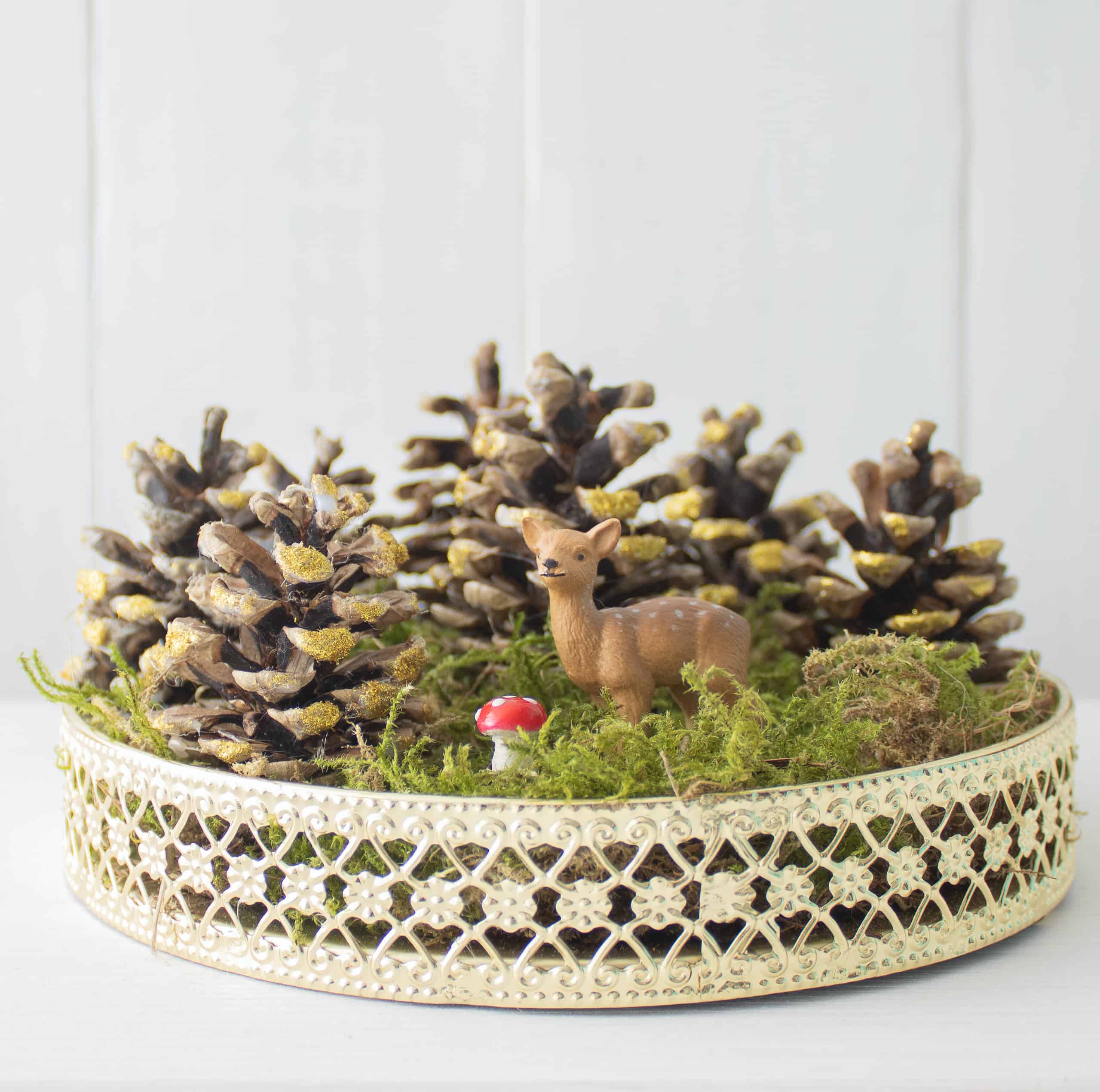 Herbstliches Stillleben mit Zapfen und Tierfigur