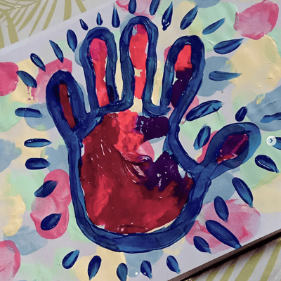 Künstlerische Darstellung einer Hand mit buntem, kreativen Design, umgeben von Farbklecksen und künstlerischen Elementen, ideal für kreative und handgemachte Kunstprojekte.