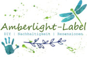Amberlight-Label Logo mit handgezeichnetem Drachenfly, grünen Blättern und Handabdruck, betont DIY, Nachhaltigkeit und Rezensionen im Bereich Handgemachtes.