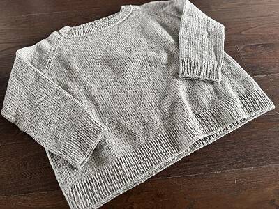 Handgefertigter Wollpullover in Beige, fein gestrickt, nachhaltige Mode, hochwertiges Handwerk, kuscheliger Winterlook, ökologischer Style, stilvolle Nachhaltigkeit, warmes Strickdesign, modisch und umweltbewusst.