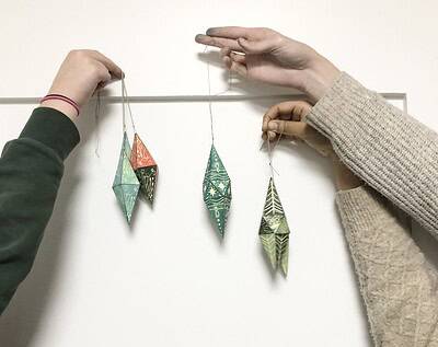 Farbenfrohe Handarbeit Weihnachtsdeko aus Papier, gefaltet zu eleganten Ornamen, ideal für DIY Adventsgirlanden und festliche Raumdekoration.