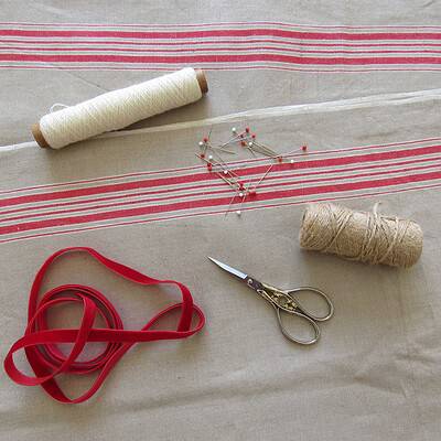 Farbenfrohes Handarbeits-Set mit Nähgarn, Stecknadeln, Stoffband, Schere und Schnur für kreatives Nähen und Basteln.