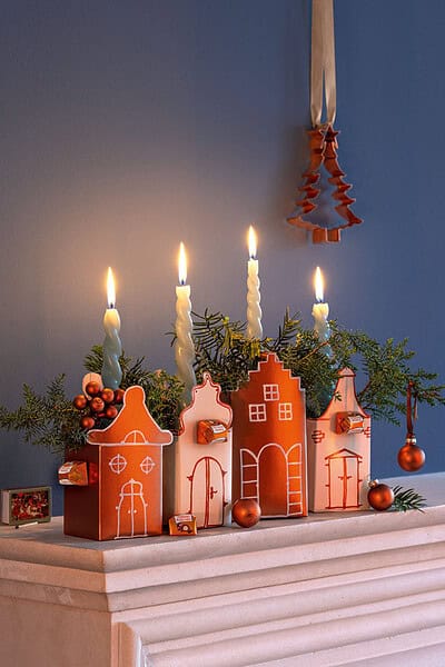 Basteldekoration für Weihnachten mit hausförmigen Kerzenhaltern und Tannenzweigen, festliche Atmosphäre, handmade Adventsschmuck, kreative Weihnachtsdeko, weihnachtliche Dekoration, Handmade Kultur, festliche DIY-Deko.