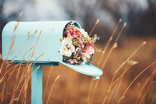 Blumenstrauß in einem blauen Briefkasten als kreative Dekoration, Handmade Kunsthandwerk, nachhaltige Geschenkideen, florale Gestaltung, Naturthema, HANDMADE Kultur.