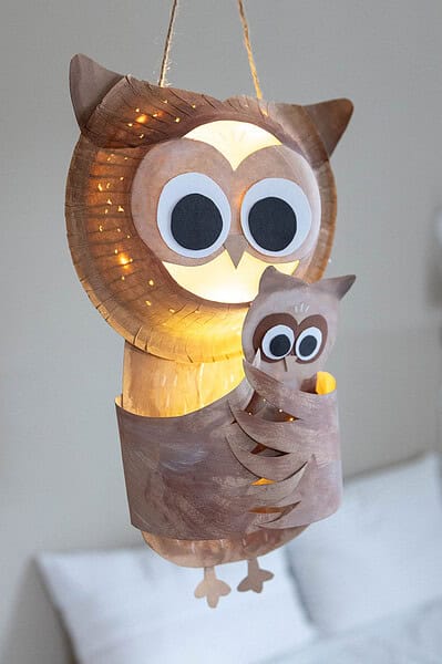 Handgemachte Eulenlaterne aus Papier und Holz, rustikale Dekoration für Wohnzimmer, kreative Handarbeit, nachhaltige DIY-Lichtquelle, unikales Ostern- oder Dekor-Accessoire.