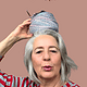 Ältere Frau mit grauem Haar trägt einen roten und weißen gestreiften Pullover, hält eine Nadel mit Garn auf ihrem Kopf, symbolisiert Handarbeit und Kreativität, mit dem Text "über mich".