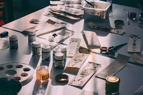 Bastelmaterialien, Farben, Pinsel, Scheren und Papier für kreative Handwerksprojekte bei HANDMADE Kultur.