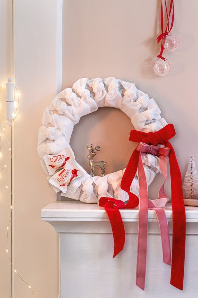 Weißer Samt-Adventskranz mit roten Schleifen und Raffaello